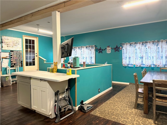 kitchen with a center island, white cabinetry, ornamental molding, and dark hardwood / wood-style floors