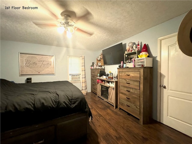 bedroom with ceiling fan, a textured ceiling, dark hardwood / wood-style flooring, and cooling unit