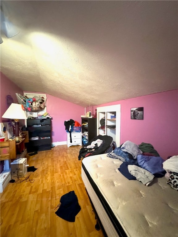 bedroom with light hardwood / wood-style flooring and a textured ceiling