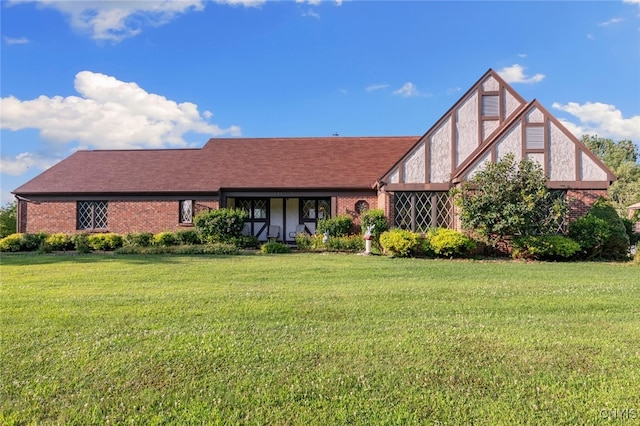 english style home featuring a front yard