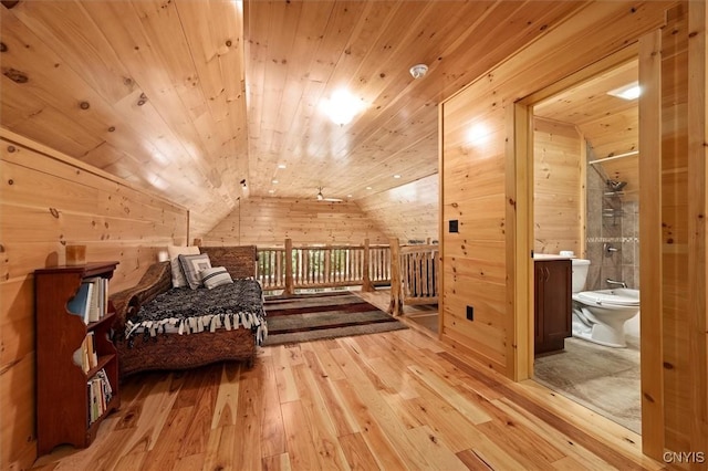 interior space with hardwood / wood-style flooring, vaulted ceiling, wooden walls, connected bathroom, and wooden ceiling