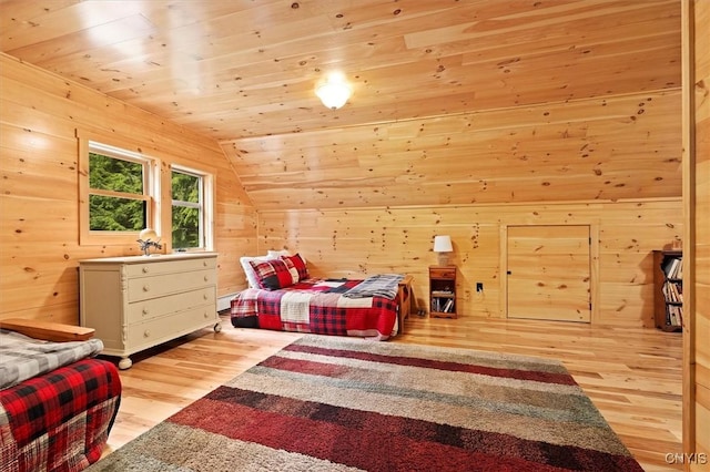 bedroom with light wood-type flooring, wood walls, vaulted ceiling, and wooden ceiling