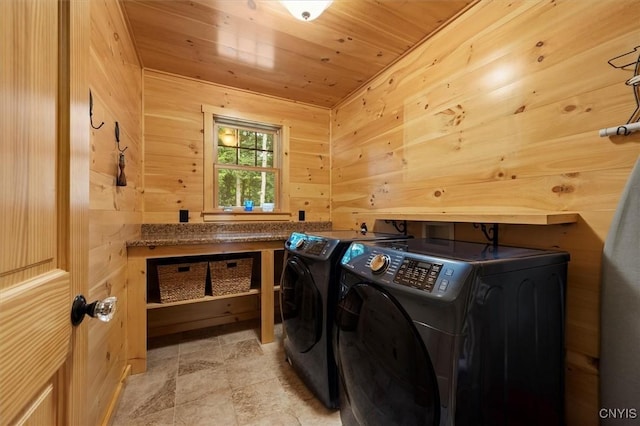 washroom featuring wood walls, washing machine and clothes dryer, and wooden ceiling