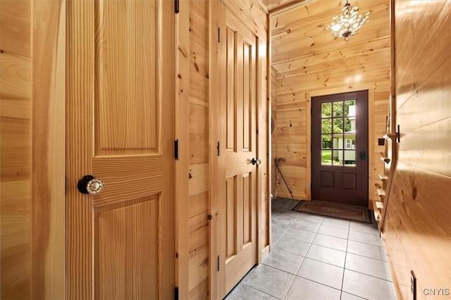 doorway to outside featuring wooden walls and light tile patterned floors