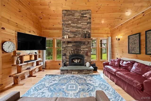 living room with light hardwood / wood-style floors, a stone fireplace, wooden ceiling, and high vaulted ceiling