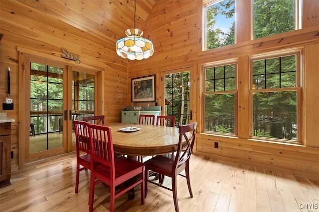 dining area featuring light hardwood / wood-style flooring, french doors, and high vaulted ceiling