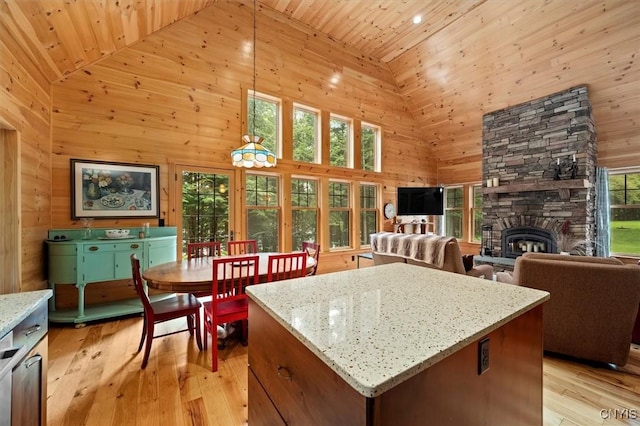 kitchen featuring light stone countertops, pendant lighting, wood ceiling, high vaulted ceiling, and a fireplace