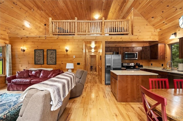 living room featuring wooden walls, light hardwood / wood-style floors, high vaulted ceiling, wooden ceiling, and sink