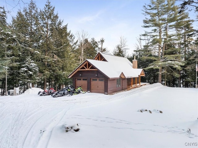 view of snowy exterior with a garage