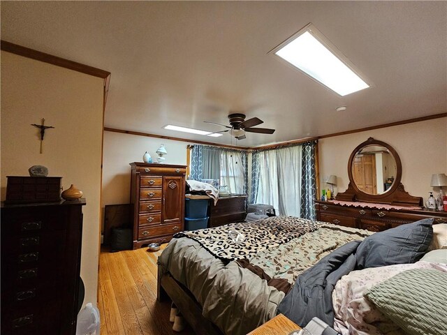 bedroom with a ceiling fan, wood finished floors, and crown molding