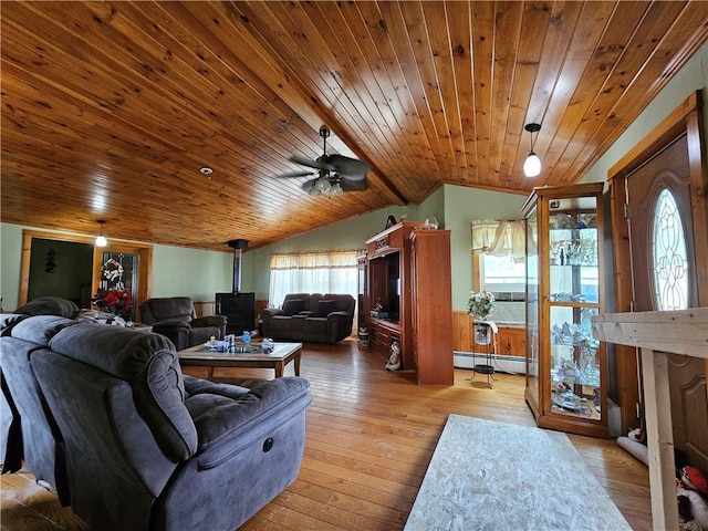 living area with wood ceiling, hardwood / wood-style flooring, a wood stove, a baseboard radiator, and lofted ceiling