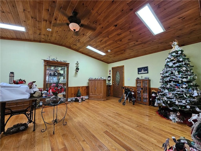interior space featuring a wainscoted wall, wooden ceiling, vaulted ceiling with skylight, and wood finished floors