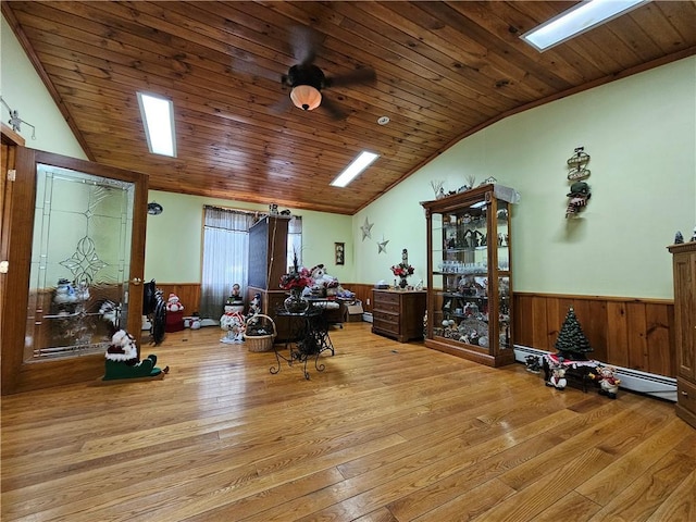 misc room featuring wainscoting, vaulted ceiling with skylight, wooden ceiling, and hardwood / wood-style flooring