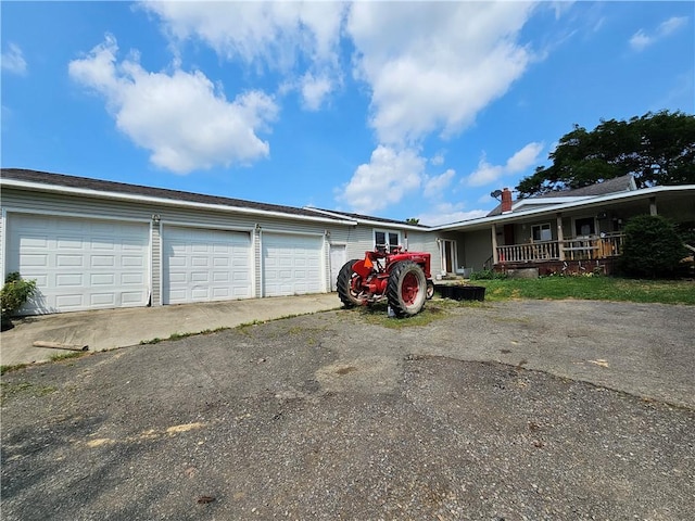 view of front of house with driveway, a porch, and a garage