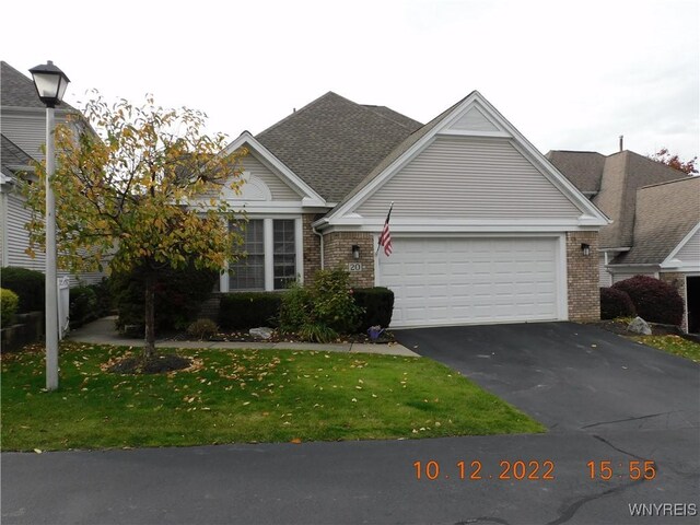 view of front of property with a garage and a front lawn