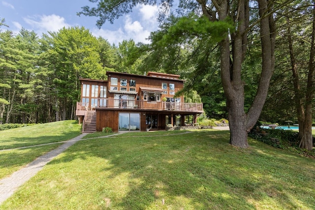 rear view of property featuring a yard and a deck