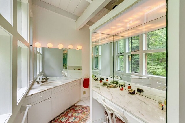 bathroom featuring tile patterned flooring, beamed ceiling, and vanity