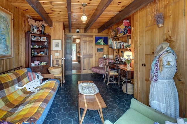 living room with wood walls, wooden ceiling, beam ceiling, and dark tile patterned floors