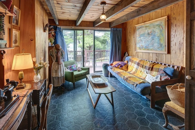 living area featuring beamed ceiling, wood walls, and wooden ceiling