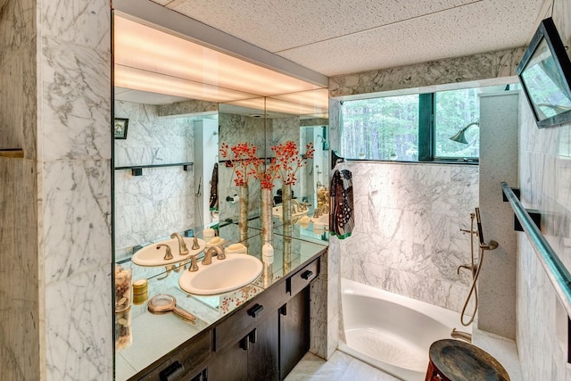 bathroom featuring vanity, tile walls, and tiled shower / bath combo