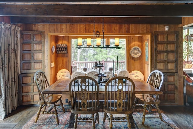 dining space with a notable chandelier, a healthy amount of sunlight, beam ceiling, and dark hardwood / wood-style flooring