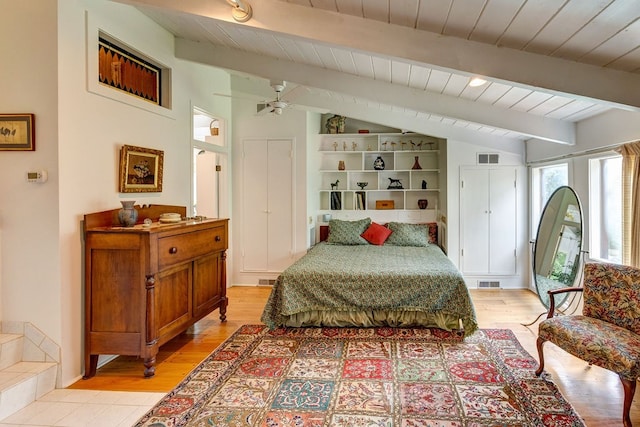 bedroom featuring ceiling fan, vaulted ceiling with beams, and light hardwood / wood-style flooring