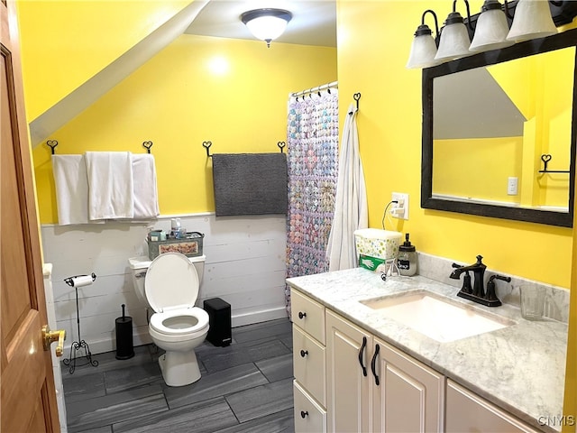 bathroom with vanity, tile walls, toilet, lofted ceiling, and tile patterned flooring