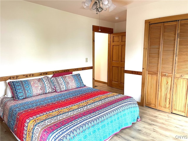 bedroom with light hardwood / wood-style flooring, a closet, and ceiling fan