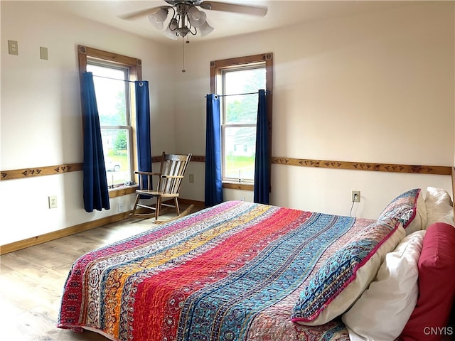 bedroom with light hardwood / wood-style flooring, multiple windows, and ceiling fan