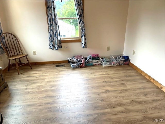 interior space with visible vents, baseboards, and wood finished floors
