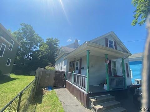 view of side of property with a yard and covered porch