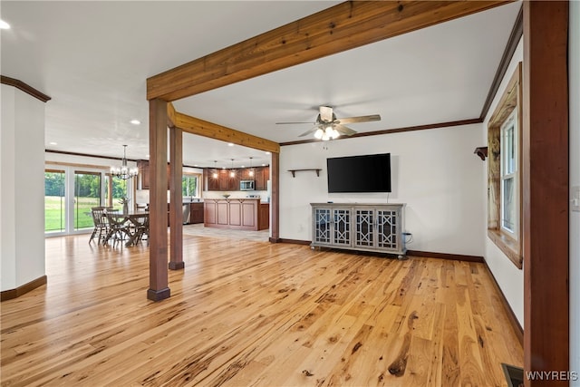 unfurnished living room featuring crown molding, light hardwood / wood-style flooring, and ceiling fan with notable chandelier