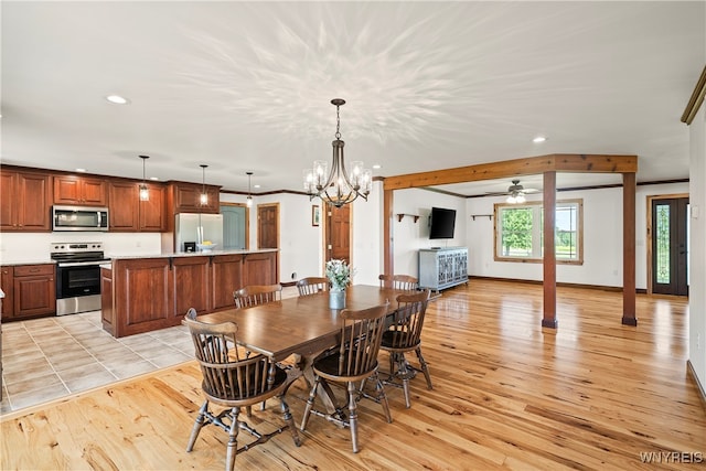 dining room with ceiling fan with notable chandelier and light hardwood / wood-style floors