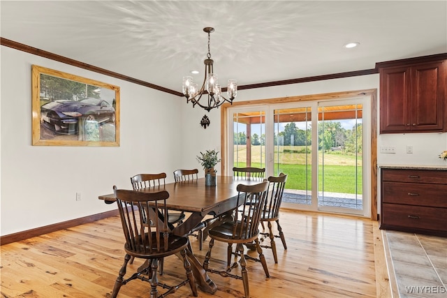 dining space with ornamental molding, a notable chandelier, and light hardwood / wood-style floors