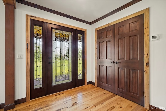 foyer entrance with light wood-type flooring and ornamental molding