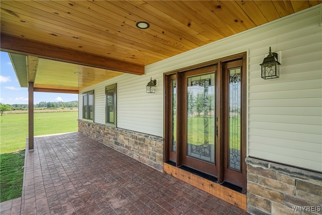 view of exterior entry with a rural view and a patio