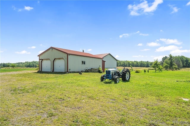 view of yard with an outdoor structure, a rural view, and a garage