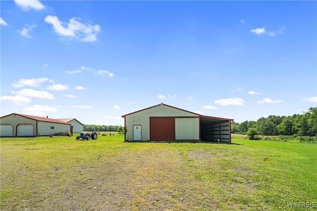 view of yard featuring an outbuilding, a rural view, and a garage