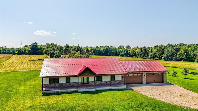 ranch-style house featuring a garage, a front yard, and a rural view