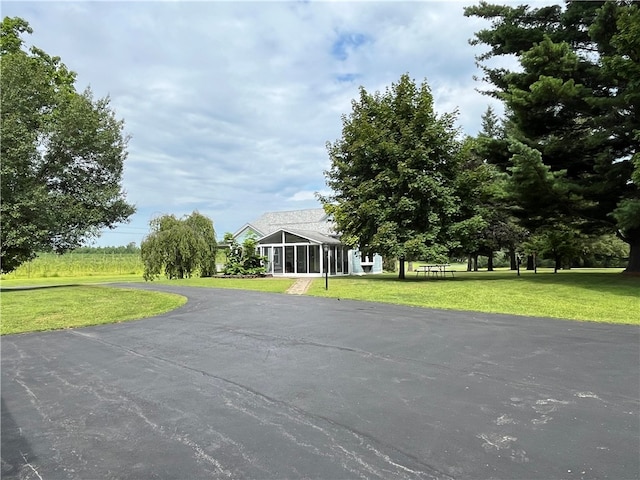 view of front facade featuring a sunroom and a front lawn