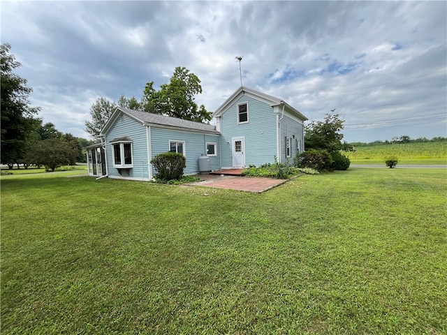 rear view of house featuring a patio and a lawn