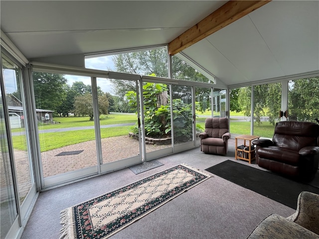 sunroom / solarium featuring a healthy amount of sunlight and vaulted ceiling with beams