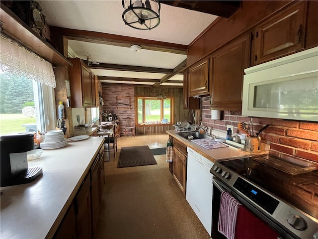 kitchen featuring sink, beamed ceiling, carpet, and white appliances