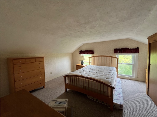 bedroom featuring carpet, lofted ceiling, and a textured ceiling