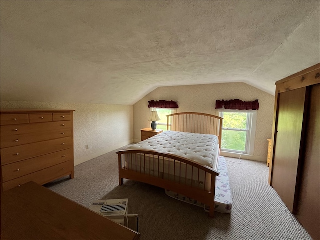 carpeted bedroom with lofted ceiling and a textured ceiling