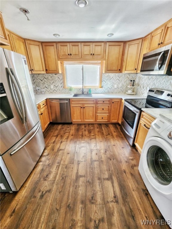 kitchen featuring washer / dryer, appliances with stainless steel finishes, and dark hardwood / wood-style flooring