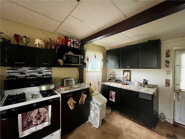 kitchen with light tile patterned flooring, tasteful backsplash, stove, and a paneled ceiling