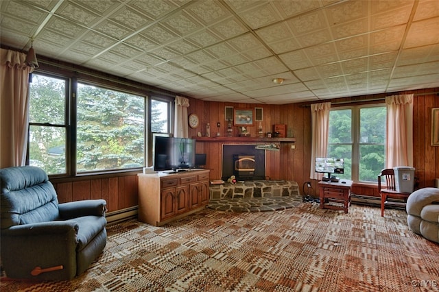 office featuring a baseboard radiator, a wood stove, and wooden walls