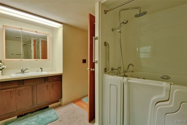 bathroom featuring washtub / shower combination, hardwood / wood-style floors, and vanity