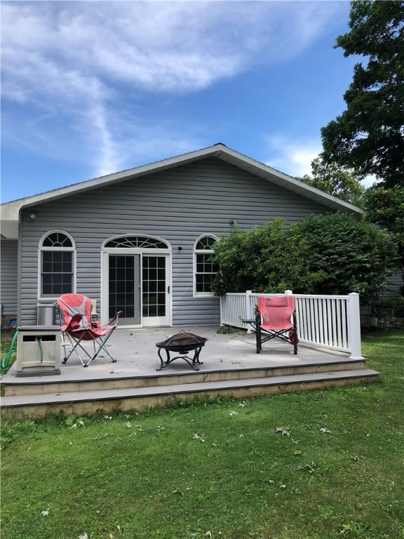 back of house featuring a wooden deck and a lawn